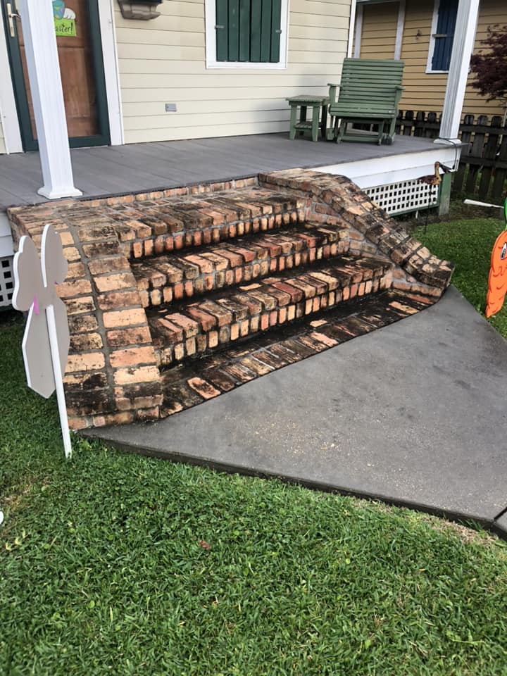 Brick front steps before pressure washing — black grime and buildup