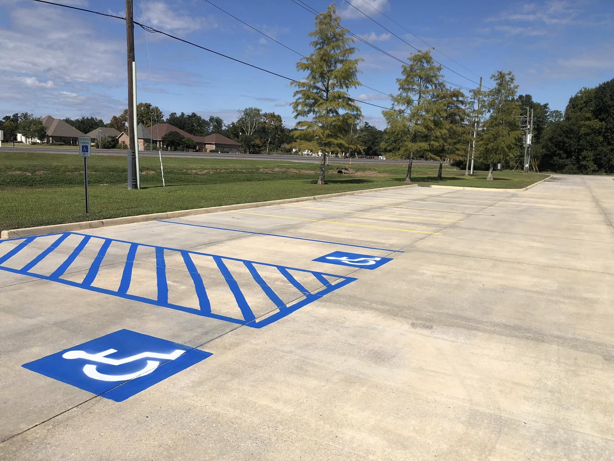 Parking lot after re-striping — fresh blue ADA handicap markings